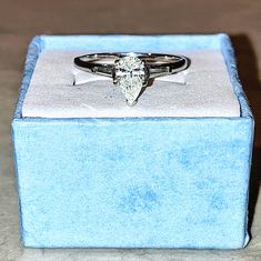 a diamond ring sitting on top of a blue box