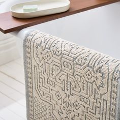 a close up of a towel on a table with a plate and bowl in the background