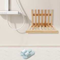 a pair of blue slippers sitting on top of a wooden shelf next to a shower head