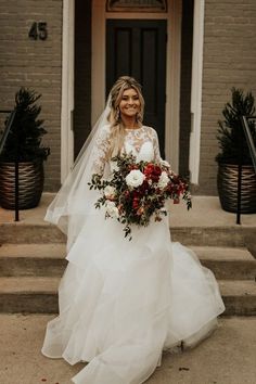 a woman in a wedding dress is standing on the steps with her bridal bouquet