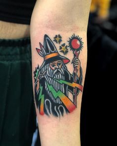 a man with a wizard hat and wand tattoo on his arm