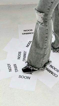 someone is standing on some paper that has words written on it and they are wearing black shoes