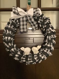 a black and white wreath with two birds on it