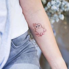 a small owl tattoo on the arm