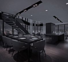 the dining room is set up for two people to enjoy their meal together, while the city lights shine in the distance