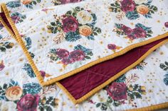 two quilted bedspreads with red and yellow trims on top of each other