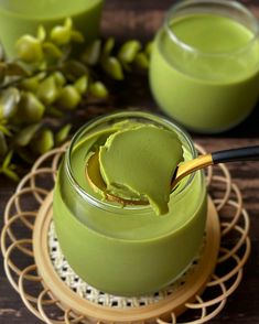 a jar filled with green liquid sitting on top of a wooden table