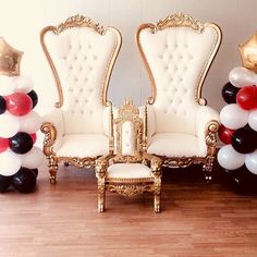 a room filled with white chairs and balloons in the shape of giant red, white and black balloons