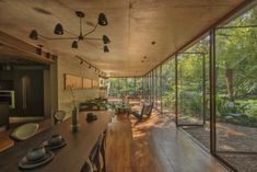 an open kitchen and dining room with wood flooring, large glass doors to the outside