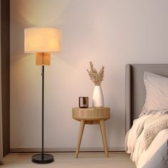 a bedroom with a bed, nightstand and lamp on the side table next to it