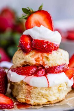 strawberry shortcakes stacked on top of each other with whipped cream and strawberries