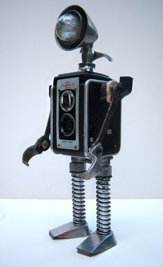 "Flash" - found object robot assemblage sculpture by Rod Abernethy Trash Puppets, Vintage Cameras Art, Robot Assemblage, Tin Can Robots, Assemblage Sculpture, Recycle Sculpture