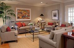 a living room with couches, chairs and a coffee table in front of two windows