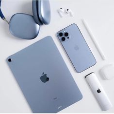 an ipad, headphones, and earbuds laid out on a white surface