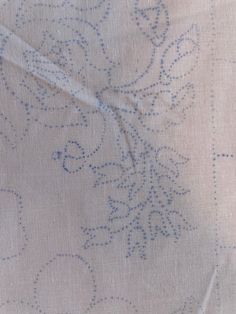 an embroidered fabric with blue dots on it