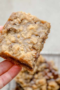 a hand holding up a piece of oatmeal cookie