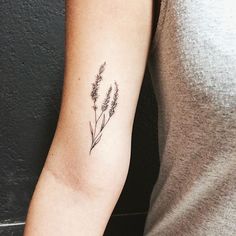 a woman with a tattoo on her arm has a lavender flower in it's left arm