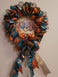 a blue and orange ribbon wreath hanging on the wall