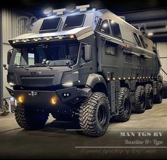 an armored vehicle is parked in a garage with lights on it's roof and the front end of its body