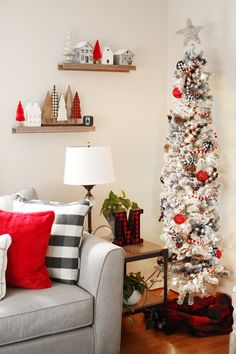 a living room with a christmas tree in the corner and other decorations on the wall