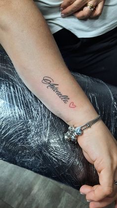 a woman's arm with a tattoo on it that says, love is in the air