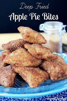 a pile of sugared donuts sitting on top of a blue plate