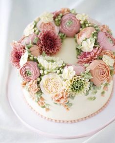 a white cake with pink and green flowers on it