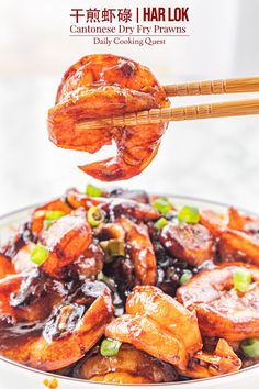 someone is holding chopsticks above a bowl of food with meat and vegetables on it