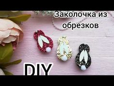 three different types of hair clips sitting on top of a wooden table next to flowers