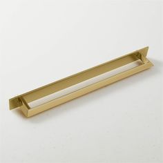 a gold drawer handle on a white surface