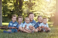 a group of young boys sitting next to each other in the grass