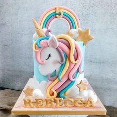 a cake decorated with an unicorn's head on top of a wooden block and stars