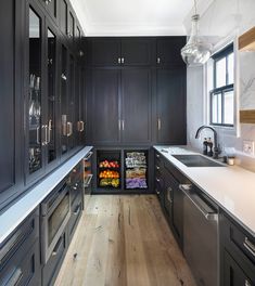 a kitchen with black cabinets and white counter tops