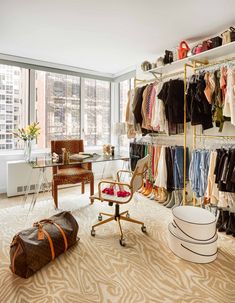 the closet is full of clothes and shoes, including an old - fashioned desk with a rolling chair