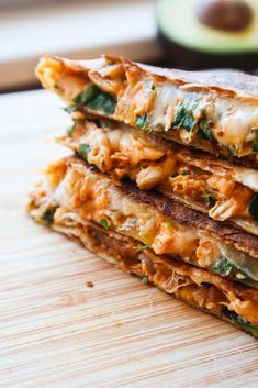 three quesadillas stacked on top of each other with cheese and spinach