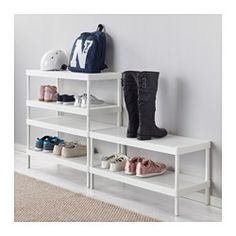 a white shelf with several pairs of shoes on it and a backpack next to it