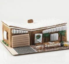 a gingerbread house decorated with icing and palm trees