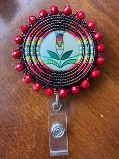 a close up of a badge on a wooden table with beads and bead work