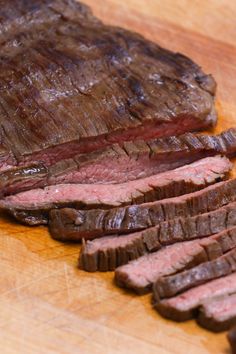 sliced steak on wooden cutting board with knife