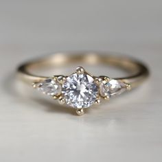 an engagement ring with three pear shaped diamonds