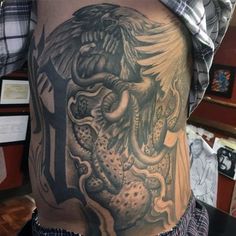 the back of a man's stomach with an octopus and eagle tattoo on it