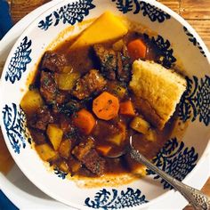 a bowl filled with stew and bread on top of a table