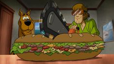 a cartoon character sitting in front of a giant sandwich with a dog looking at it