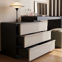 a dresser with three drawers and a lamp