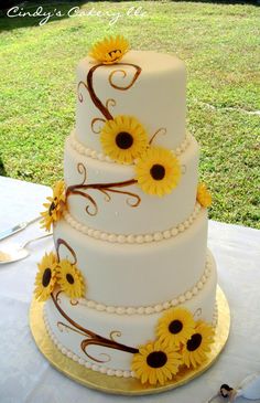 a three tiered cake with sunflowers on it