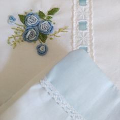 the blue flowers are embroidered onto the white sheets