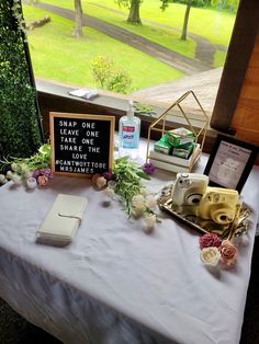 a table that has some flowers on it and a cell phone sitting on top of it