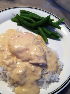 a white plate topped with rice covered in gravy and green beans