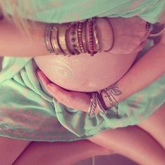 a pregnant woman with bracelets on her belly