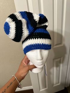 a hand is holding up a crocheted hat